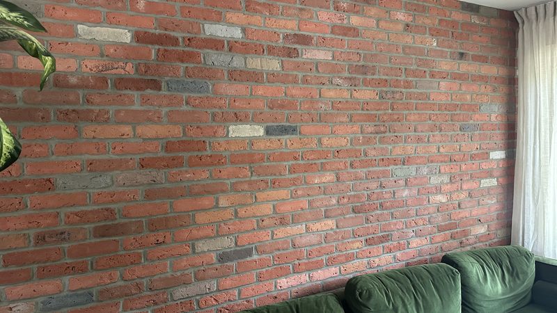 Mur de brique rouge monté à l'intérieur d'un salon