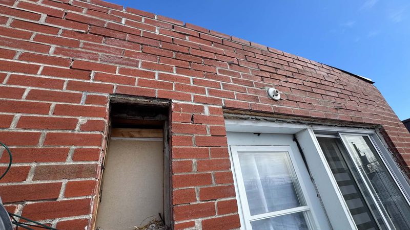 Ouverture pratiquée dans un mur de brique pour reprendre une section déformée